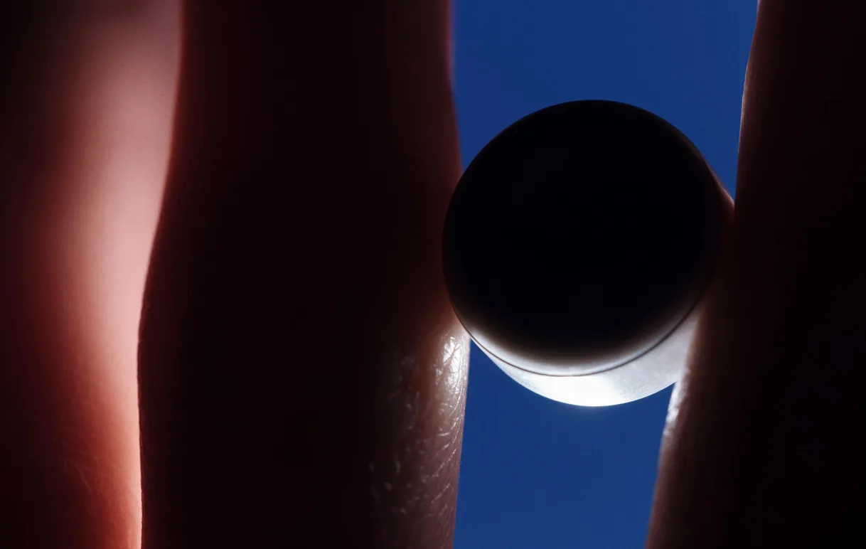 The Atlas 1.0 held between two fingertips against the sky